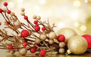 Red and gold Christmas baubles on background of defocused golden lights. Shallow DOF.